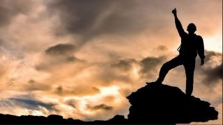 picture of man standing at top of cliff