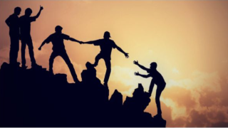 people helping each other in rock climbing